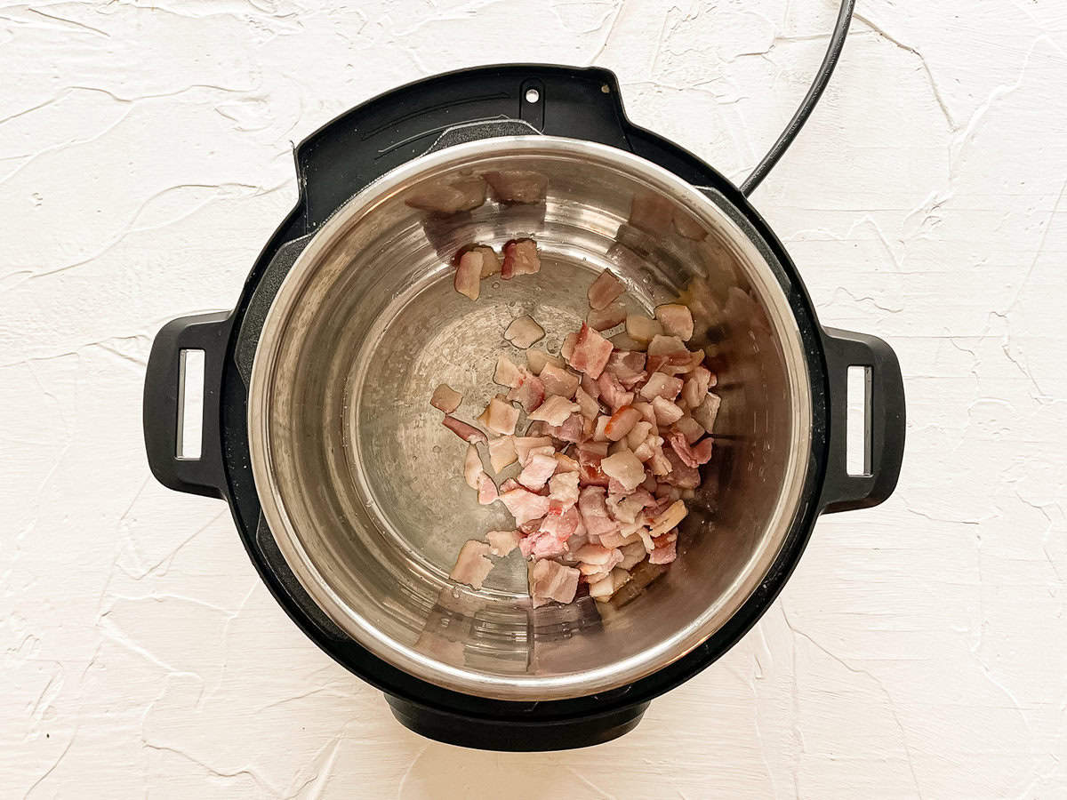 Chopped up bacon sauteeing in an Instant Pot.