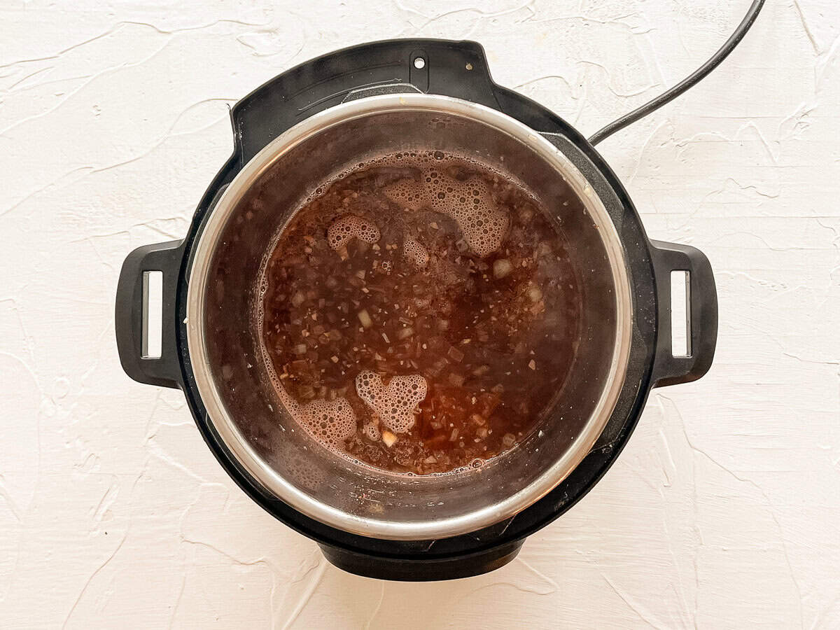 Beef broth in an Instant Pot with sauteed onions.