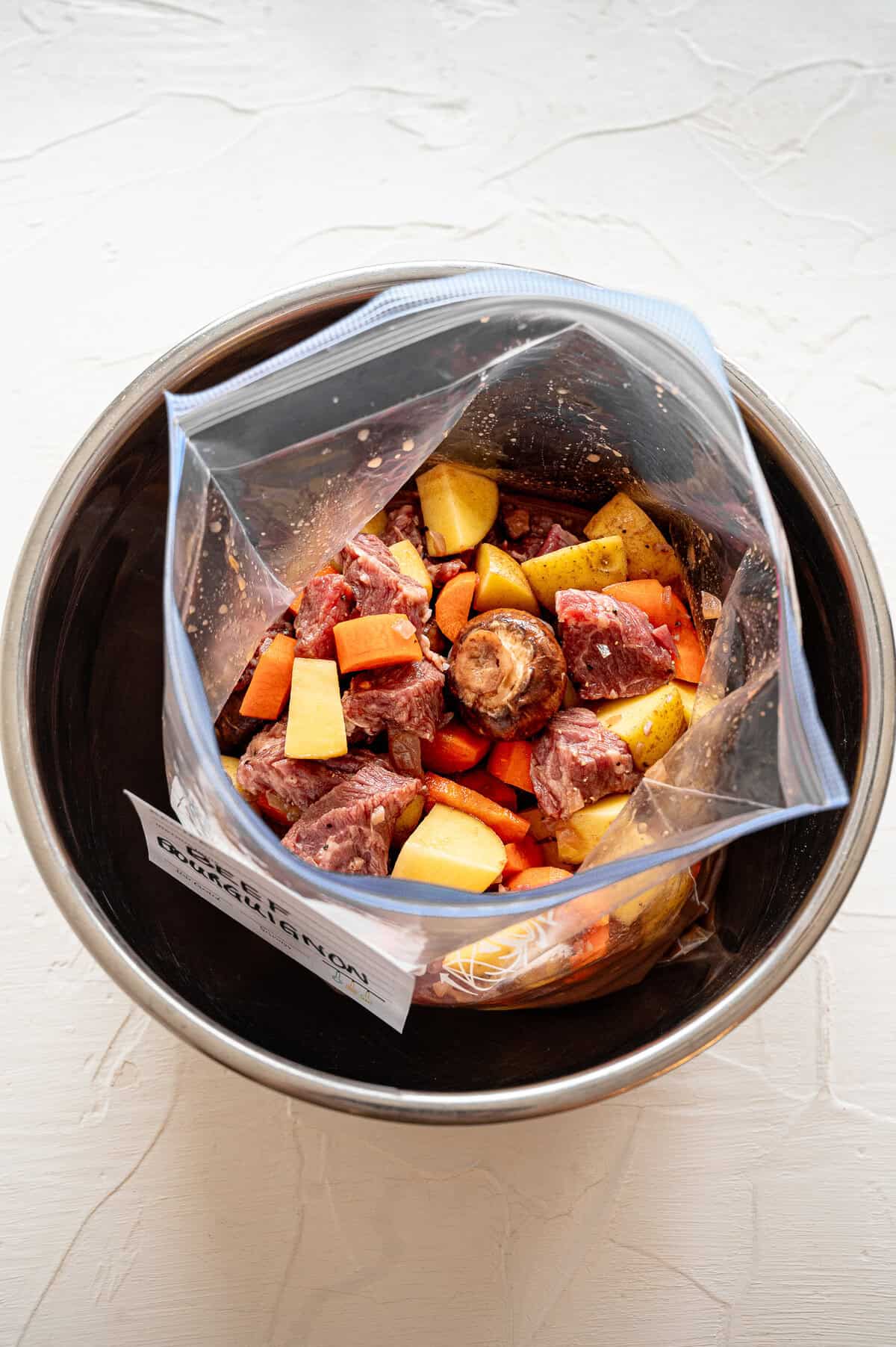 Beef bourguignon ingredients in a freezer-safe bag inside an Instant Pot liner to be frozen.