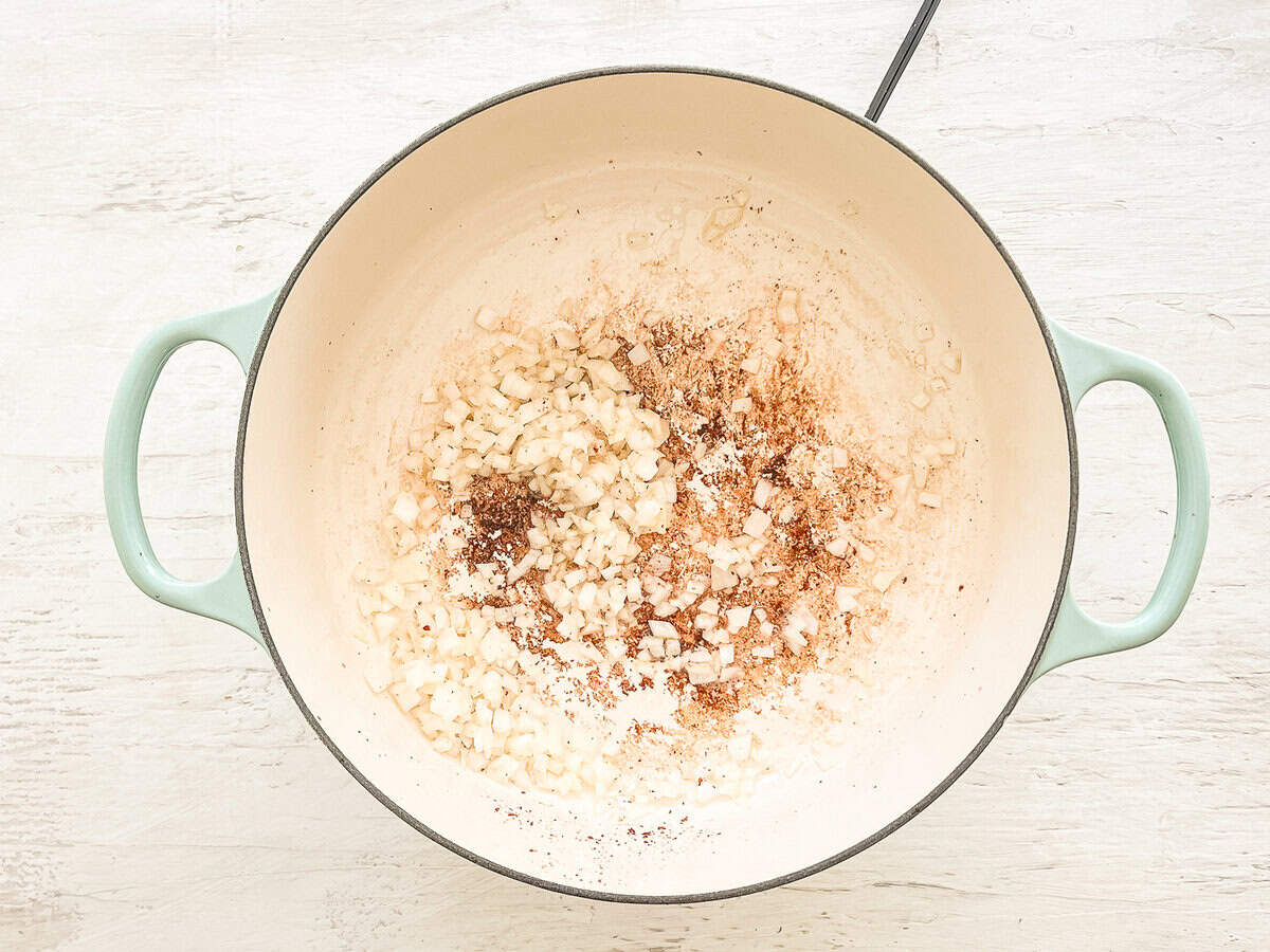 Onions being sauted in bacon grease in a pot.