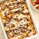 Overnight cinnamon roll casserole and a fruit salad ready to be served.