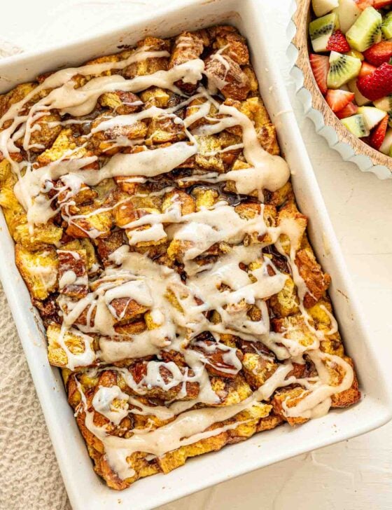 Overnight cinnamon roll casserole and a fruit salad ready to be served.