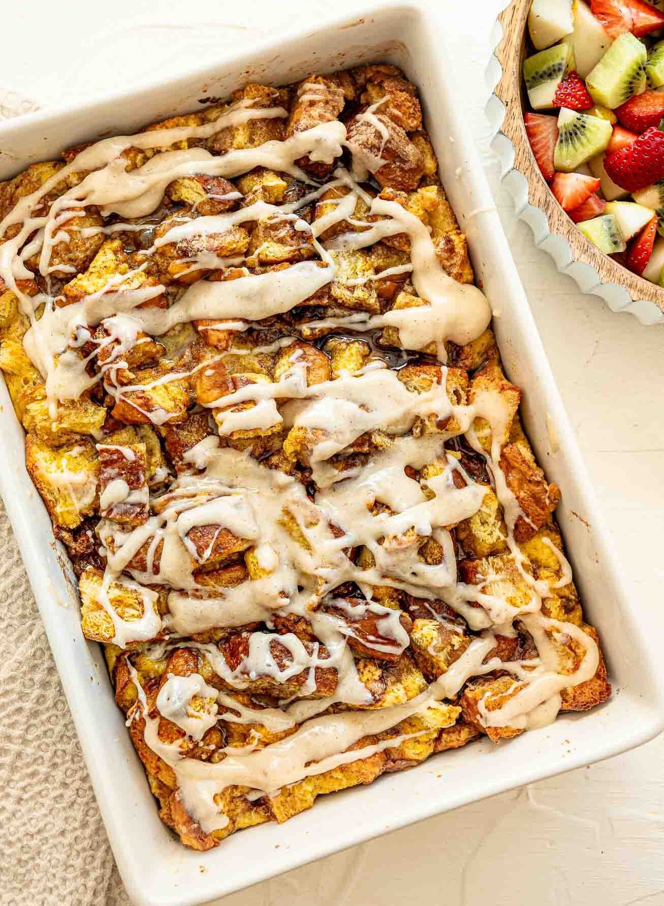 Overnight cinnamon roll casserole and a fruit salad ready to be served to a large group.