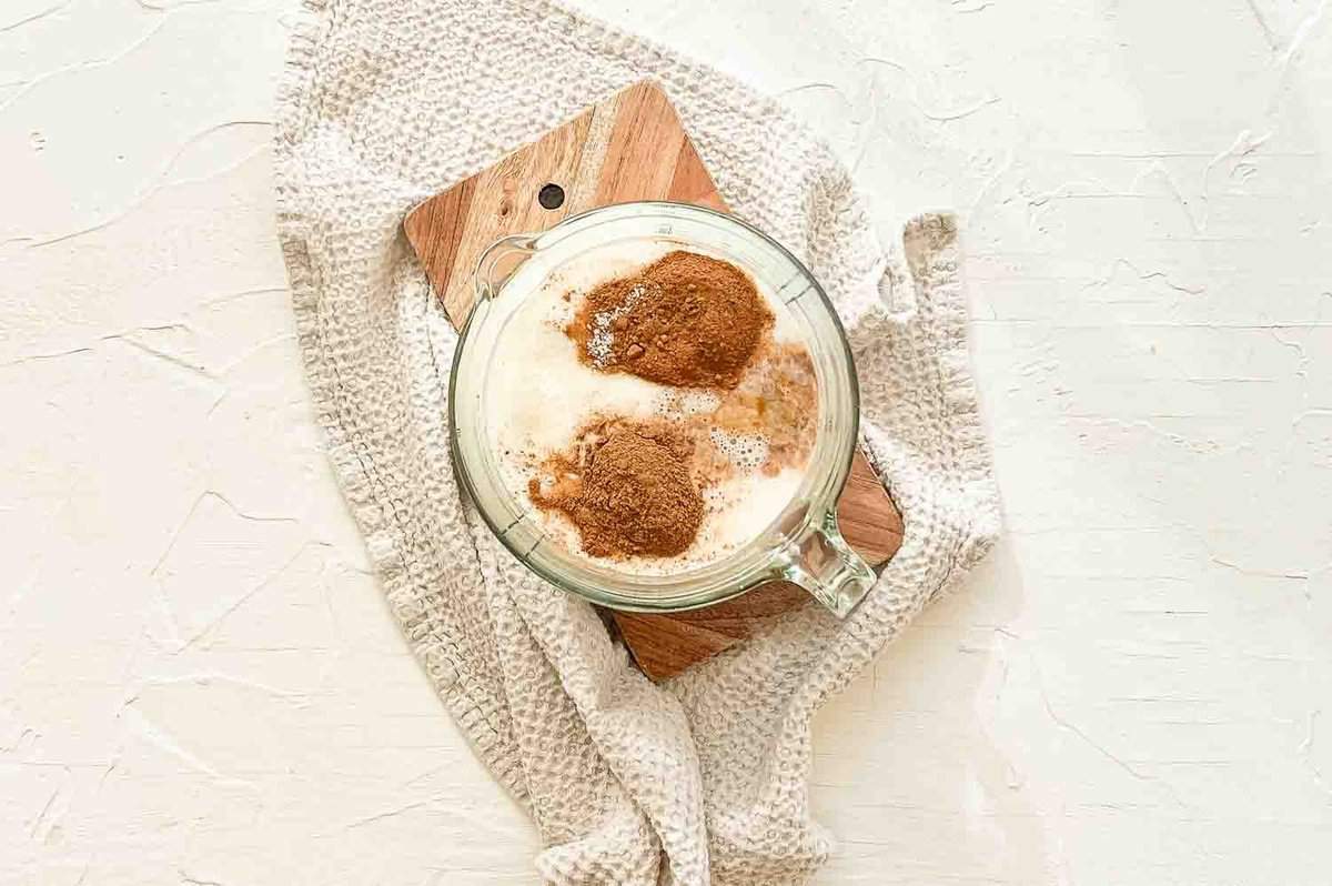 A mixing bowl with wet ingredients for cinnamon roll casserole.