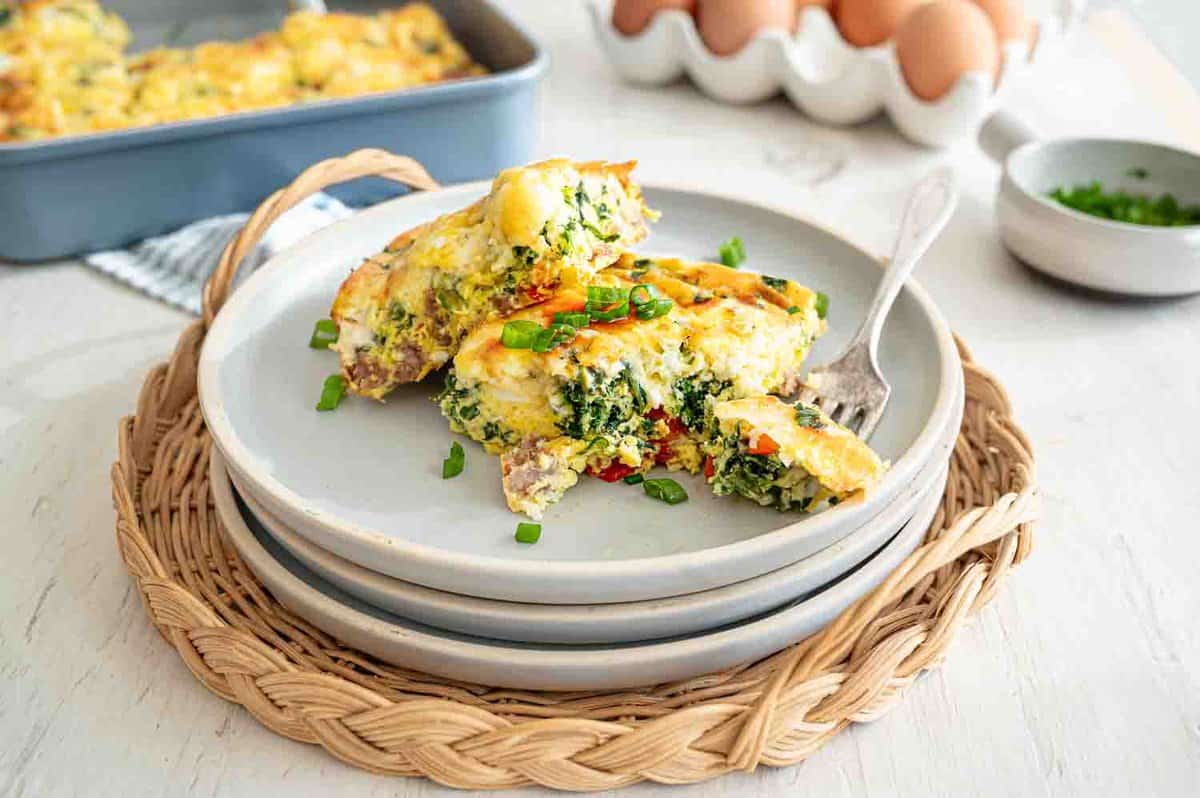 Two servings of Mediterranean low carb breakfast casserole stacked on a plate with a fork.