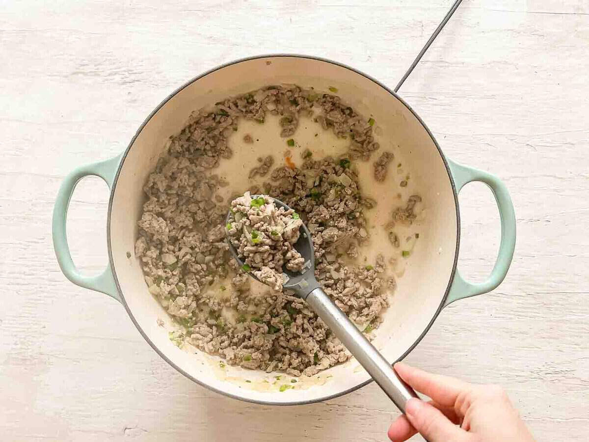 Ground turkey cooking in a ceramic pot.