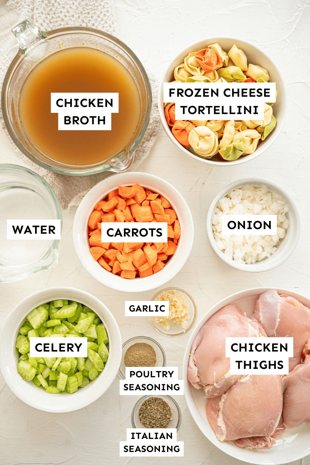 Chicken tortellini soup ingredients measured out in bowls and labeled.