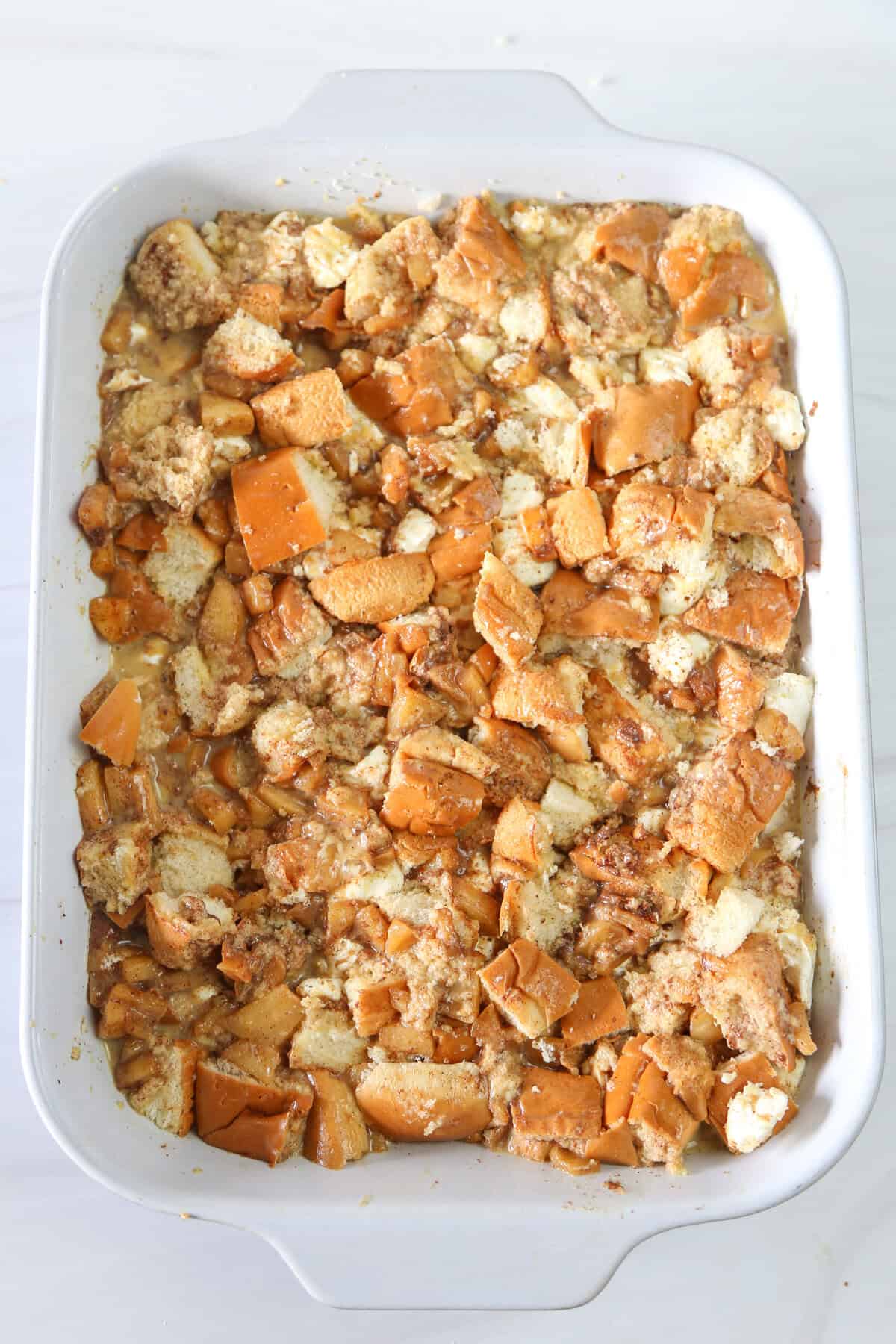 Bread pieces with an egg mixture poured over them ready for the oven to make french toast casserole.