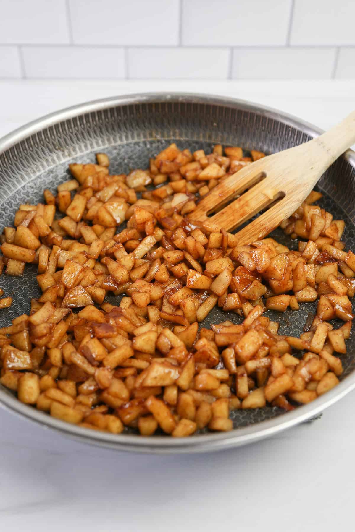 A skillet of apple pieces cooked with cinnamon and other spices.