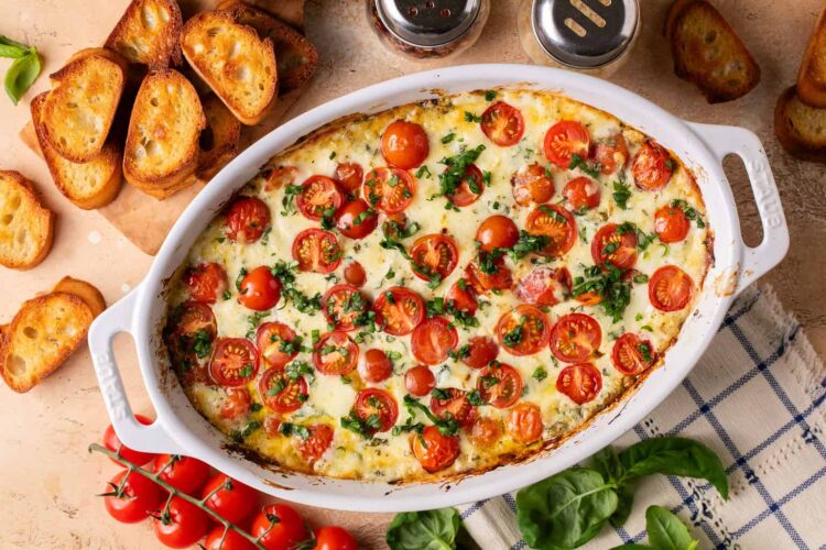 Caprese dip in an oval white baking dish.