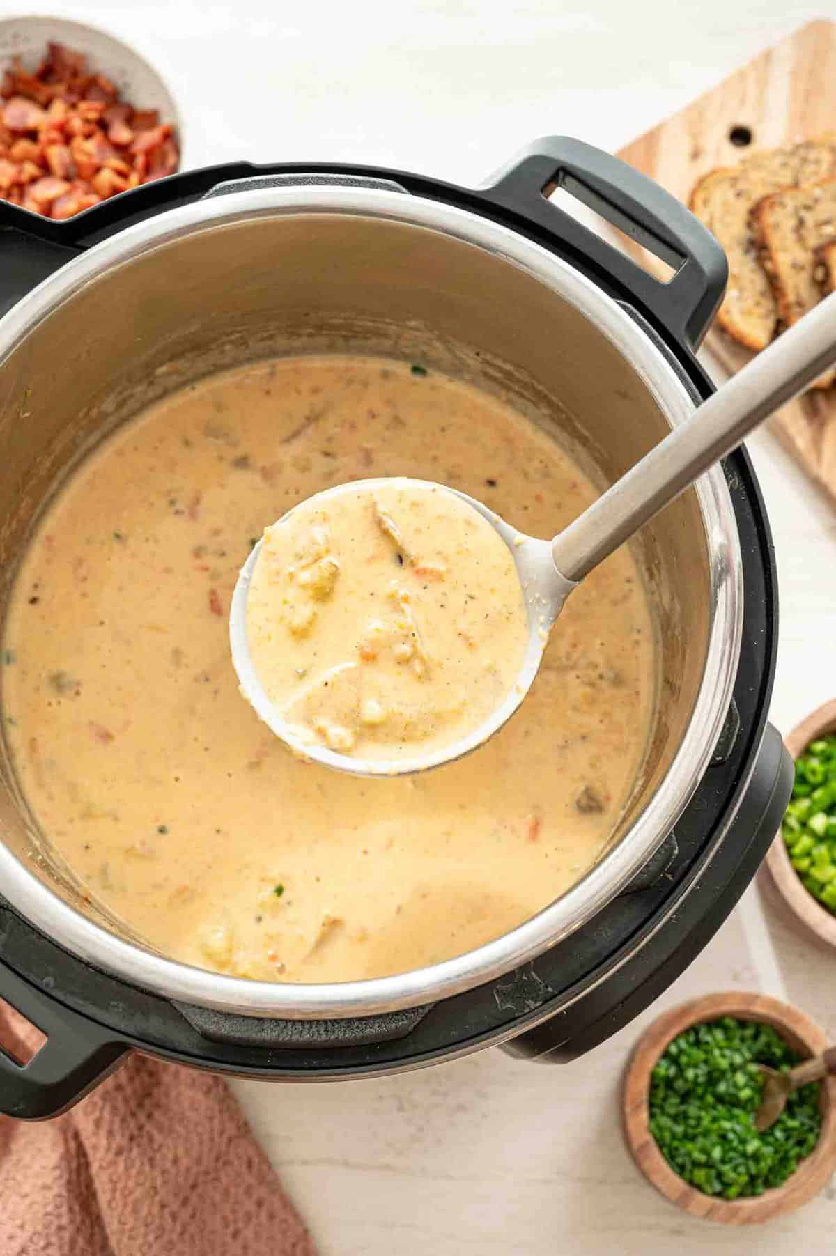 Cheddar and bacon potato soup being ladled out of an Instant Pot.