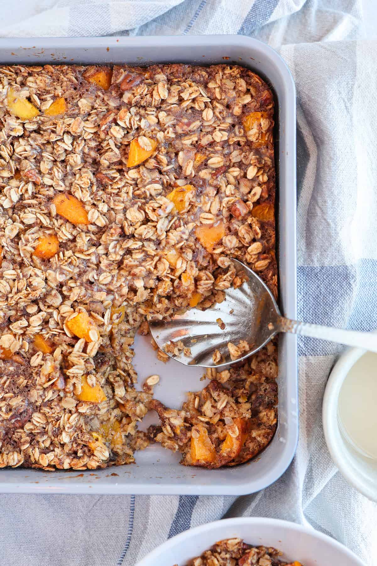 A baking dish with peaches and cream baked oatmeal.