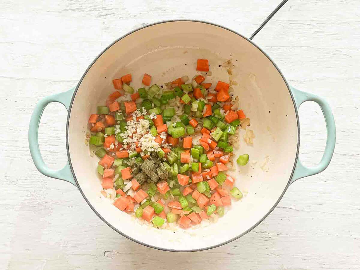 Ground thyme and minced garlic dumped on top of sauted onions, carrots, and celery to start Boursin chicken and wild rice soup.