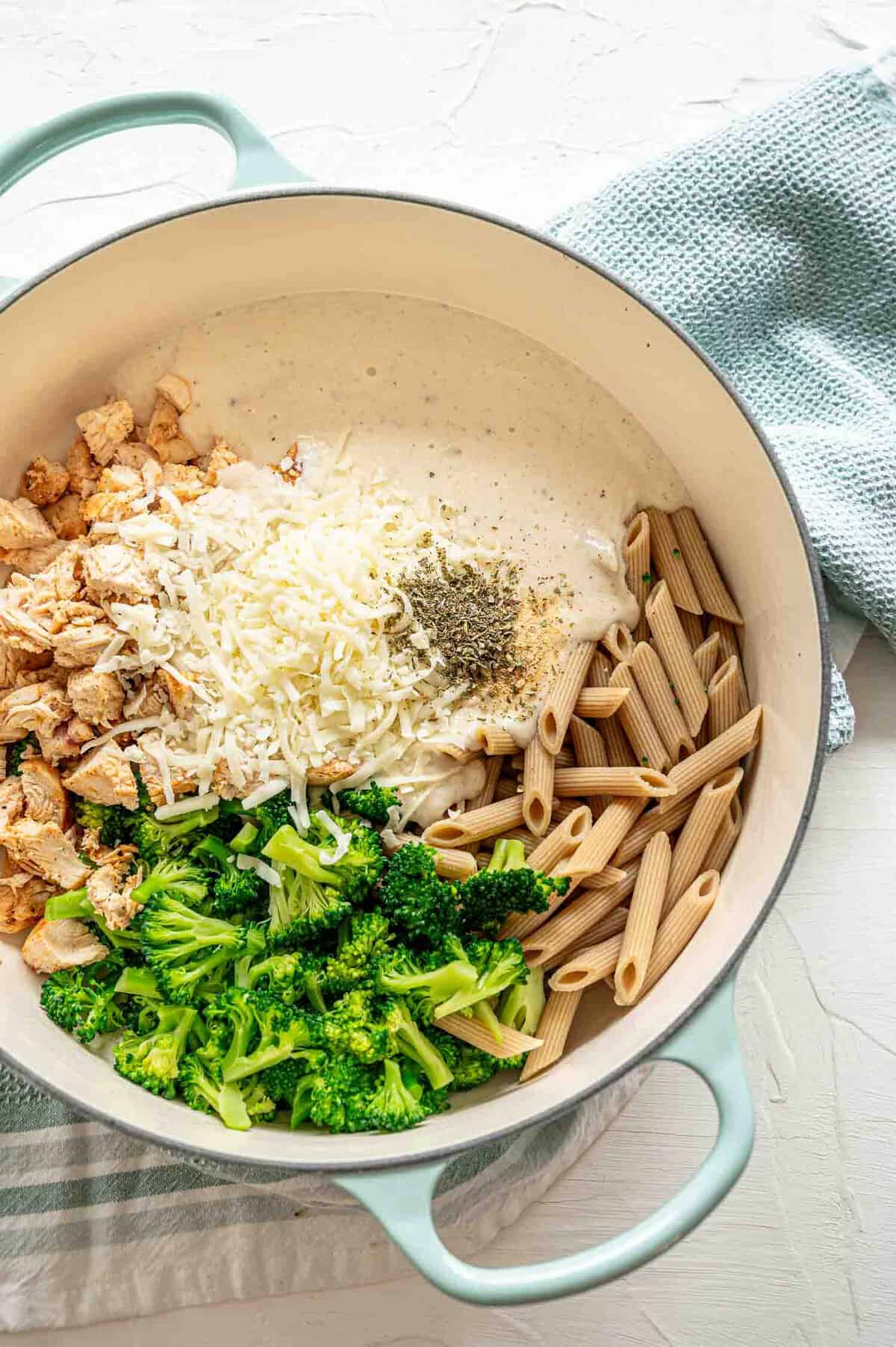 Ingredients for chicken broccoli alfredo bake in a pot waiting to be stirred.