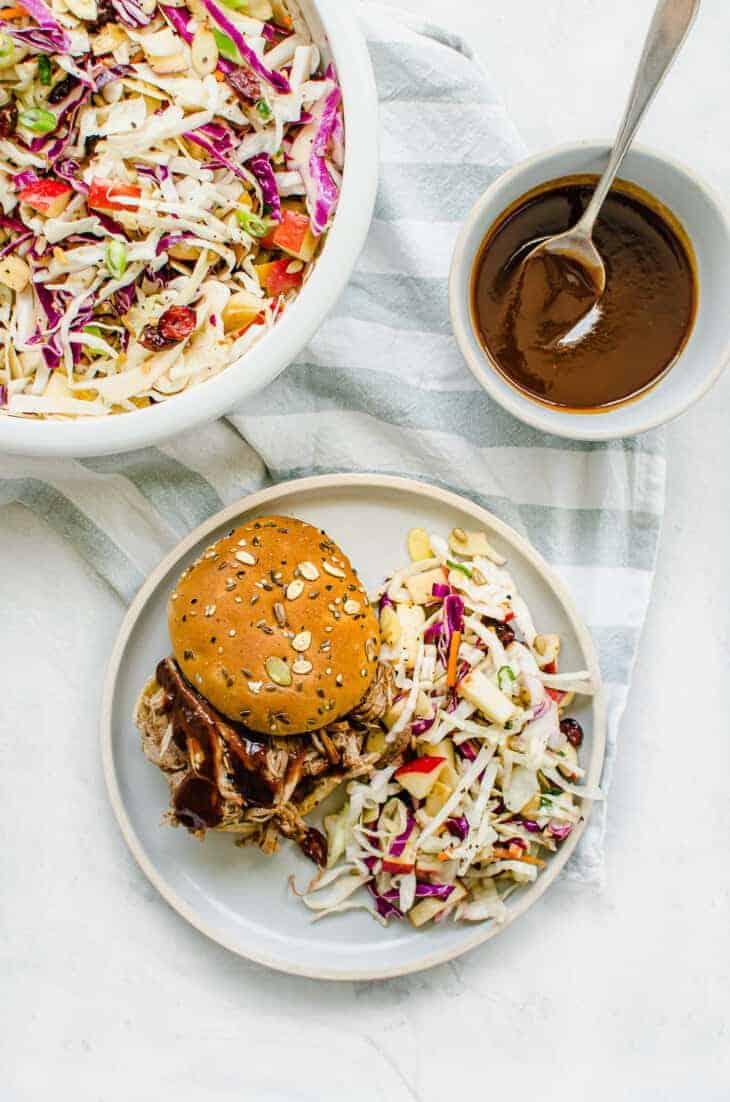 Pulled pork sandwich with vinegar-based coleslaw next to it.