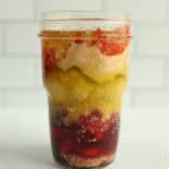 A small mason jar layered with ingredients of homemade Italian Parmesan salad dressing.