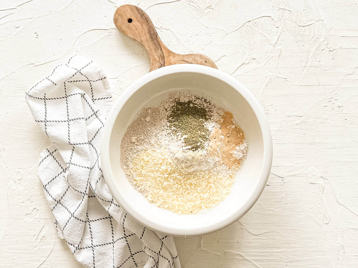 Dry ingredients including flour, Parmesan cheese, garlic powder in a mixing bowl.