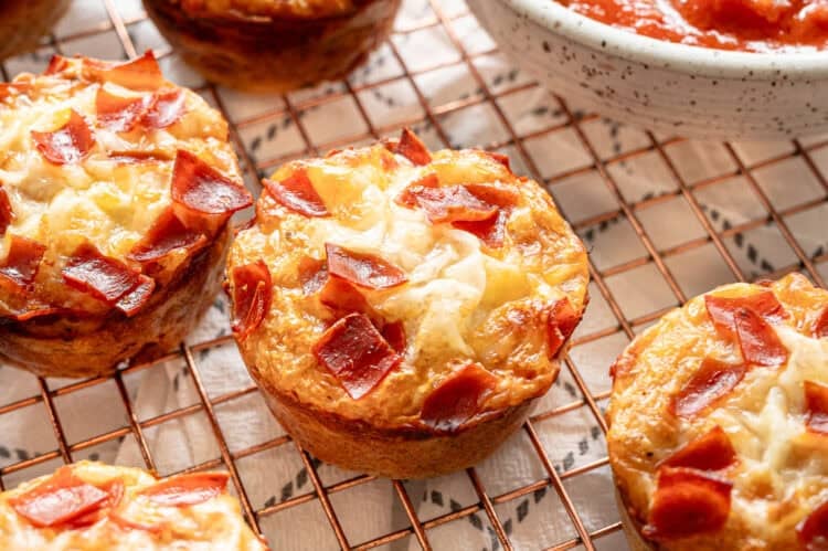 Pizza muffins with quartered pepperonis on top.