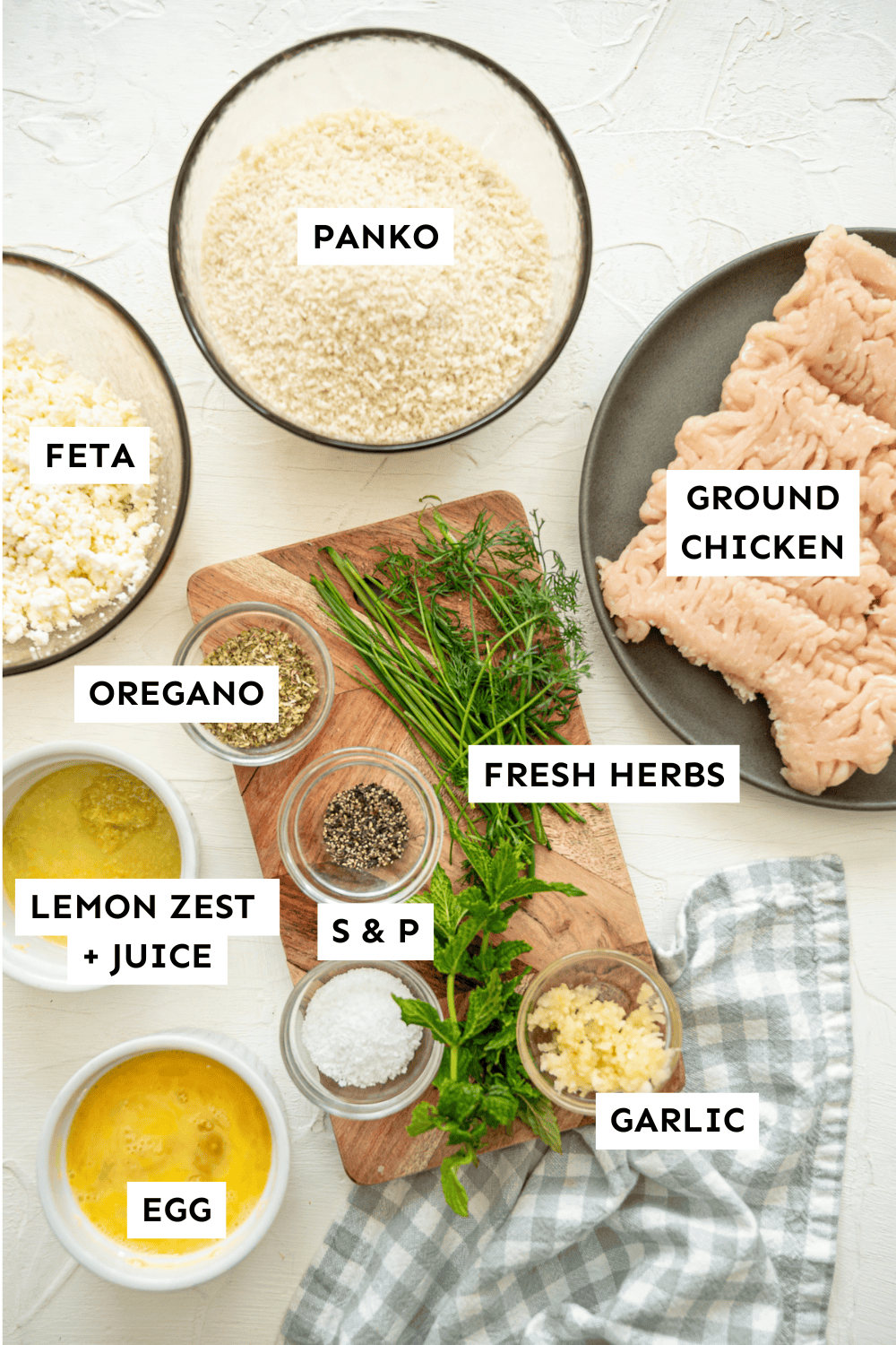 Ingredients in bowls and on plates, such as ground chicken, feta, panko, fresh herbs, lemon zest and juice, and more.
