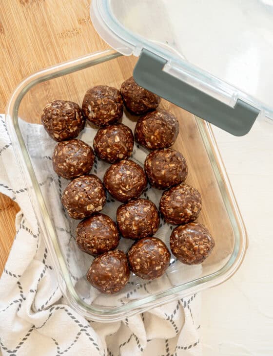 A glass container of chocolate peanut butter oatmeal bites in a single layer ready to be stored in the freezer.