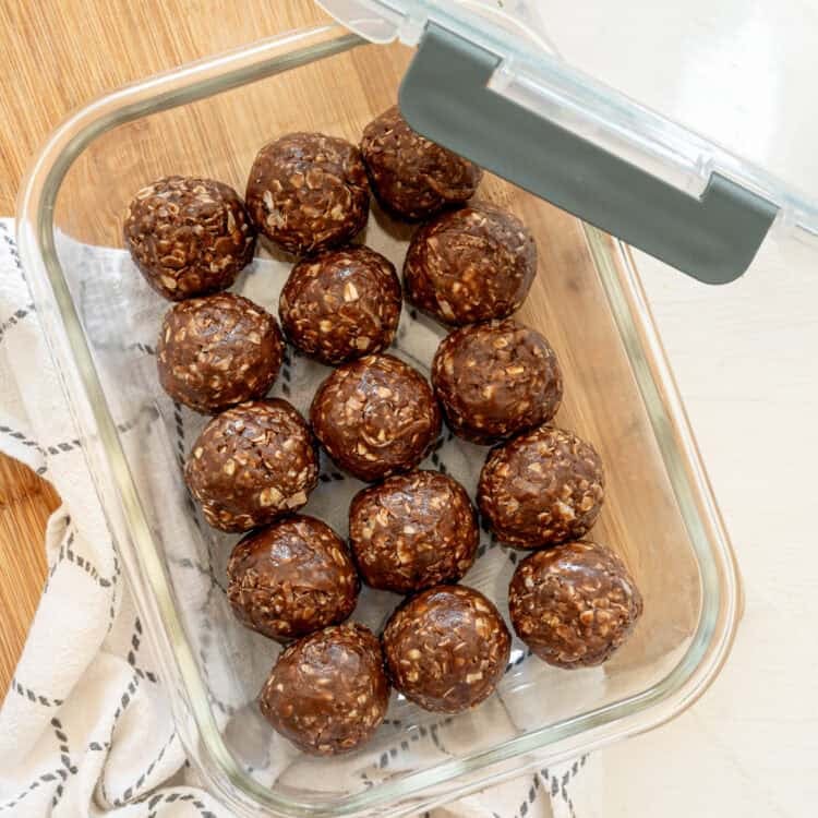 A glass container of chocolate peanut butter oatmeal bites in a single layer ready to be stored in the freezer.