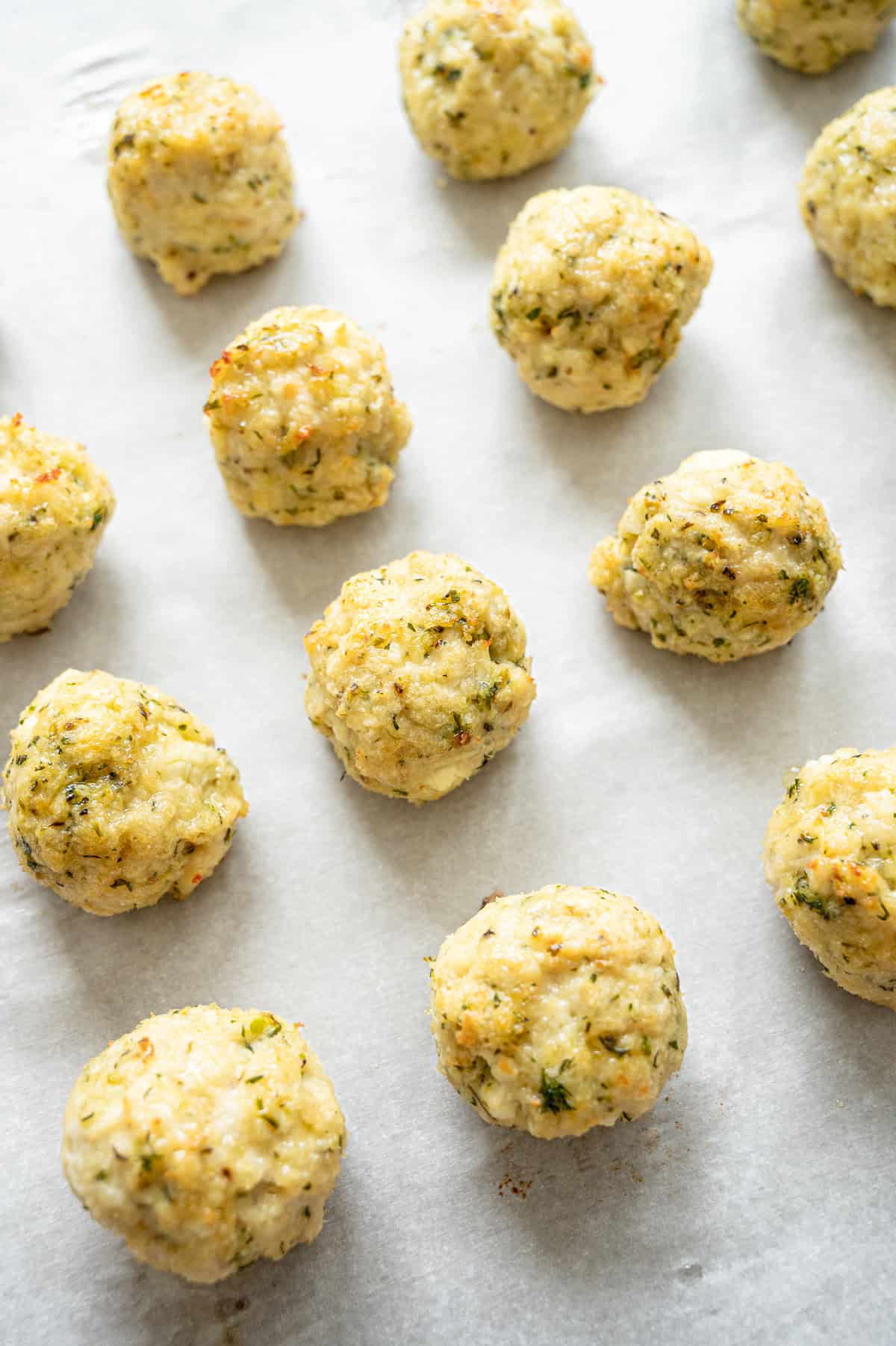 baked Greek chicken meatballs on a sheet pan.