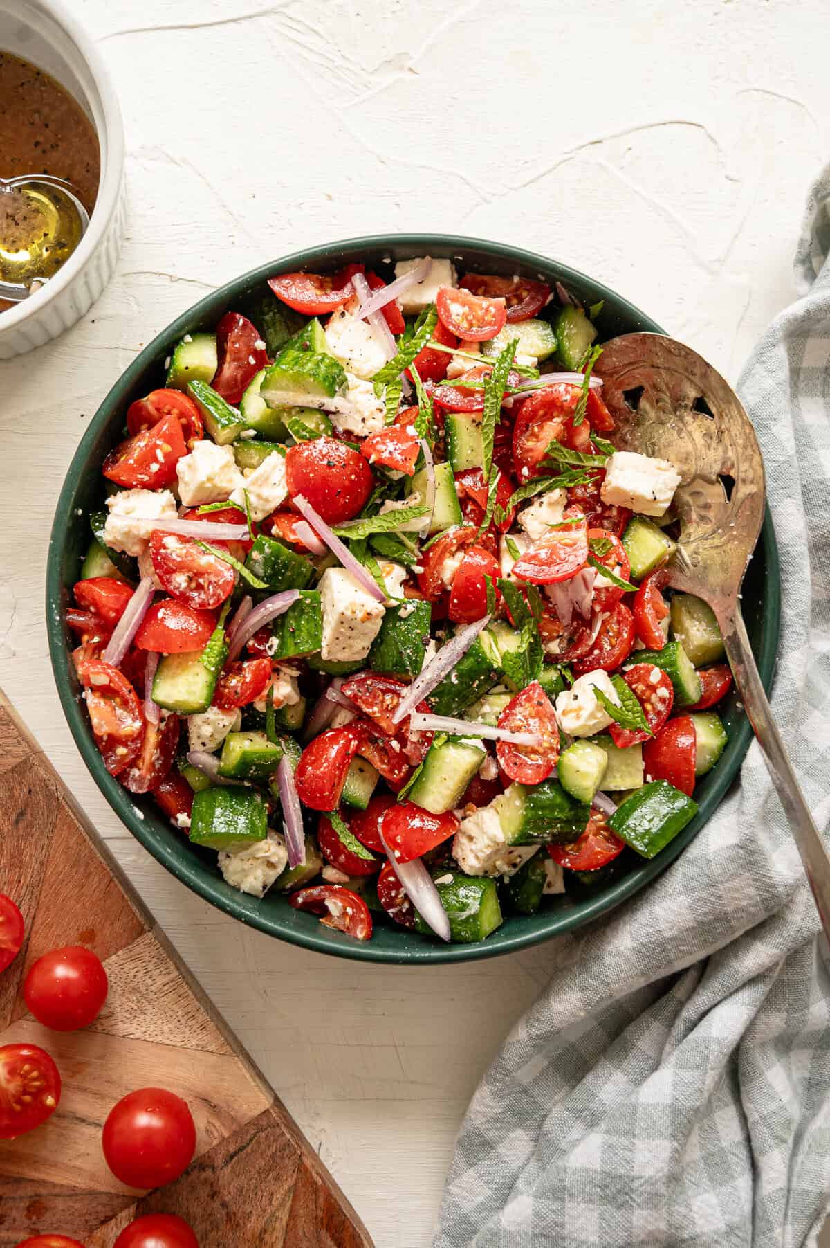 Cucumber tomato feta salad served in a teal bowl.