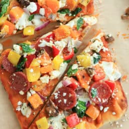 A rectangle flatbread pizza cut into triangles for serving.