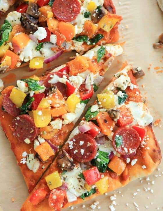 A rectangle flatbread pizza cut into triangles for serving.