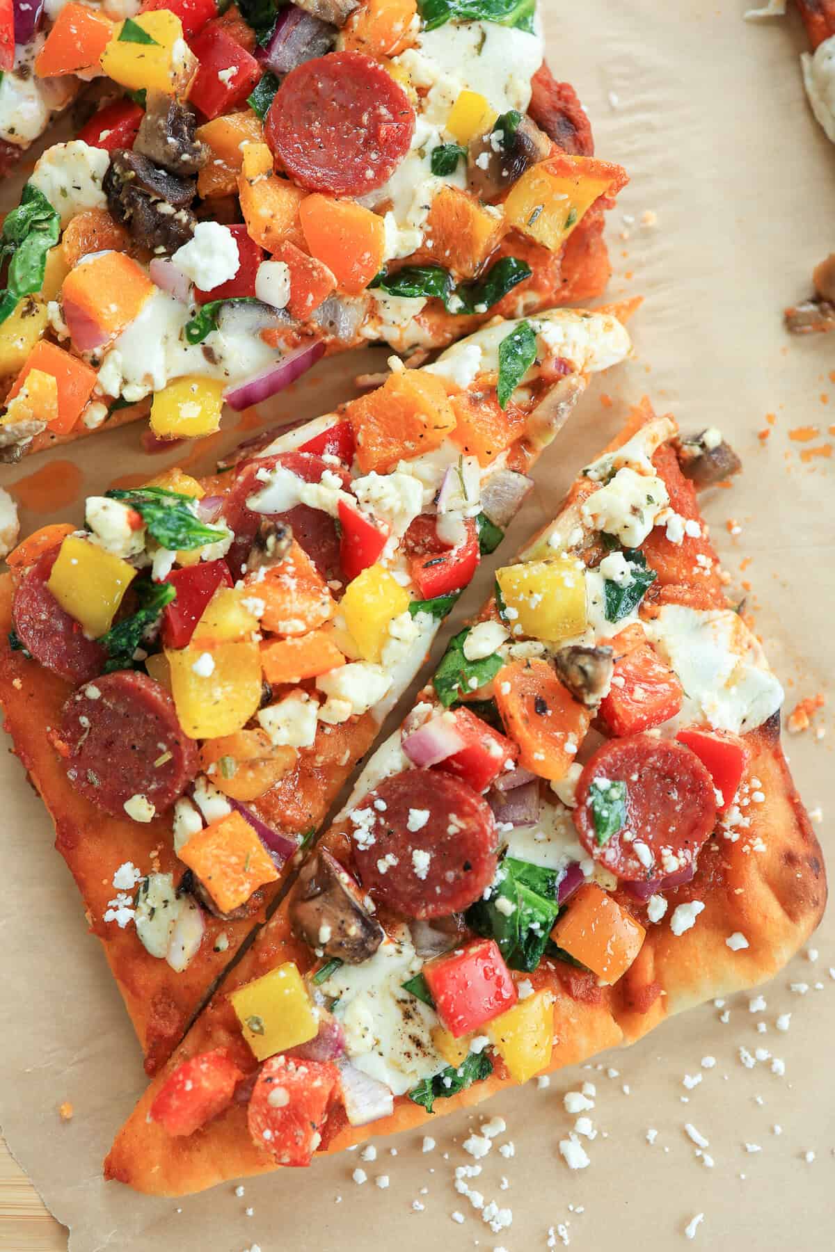 A rectangle flatbread pizza cut into triangles for serving.