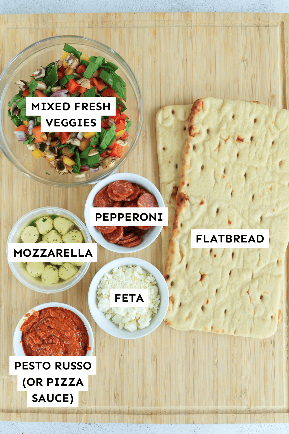 Ingredients for Veggie Flatbread Pizzas on a cutting board.