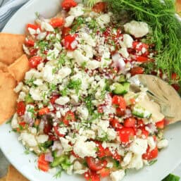 A plate with Greek Dip with Pita Chips.