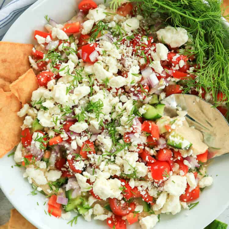 A plate with Greek Dip with Pita Chips.