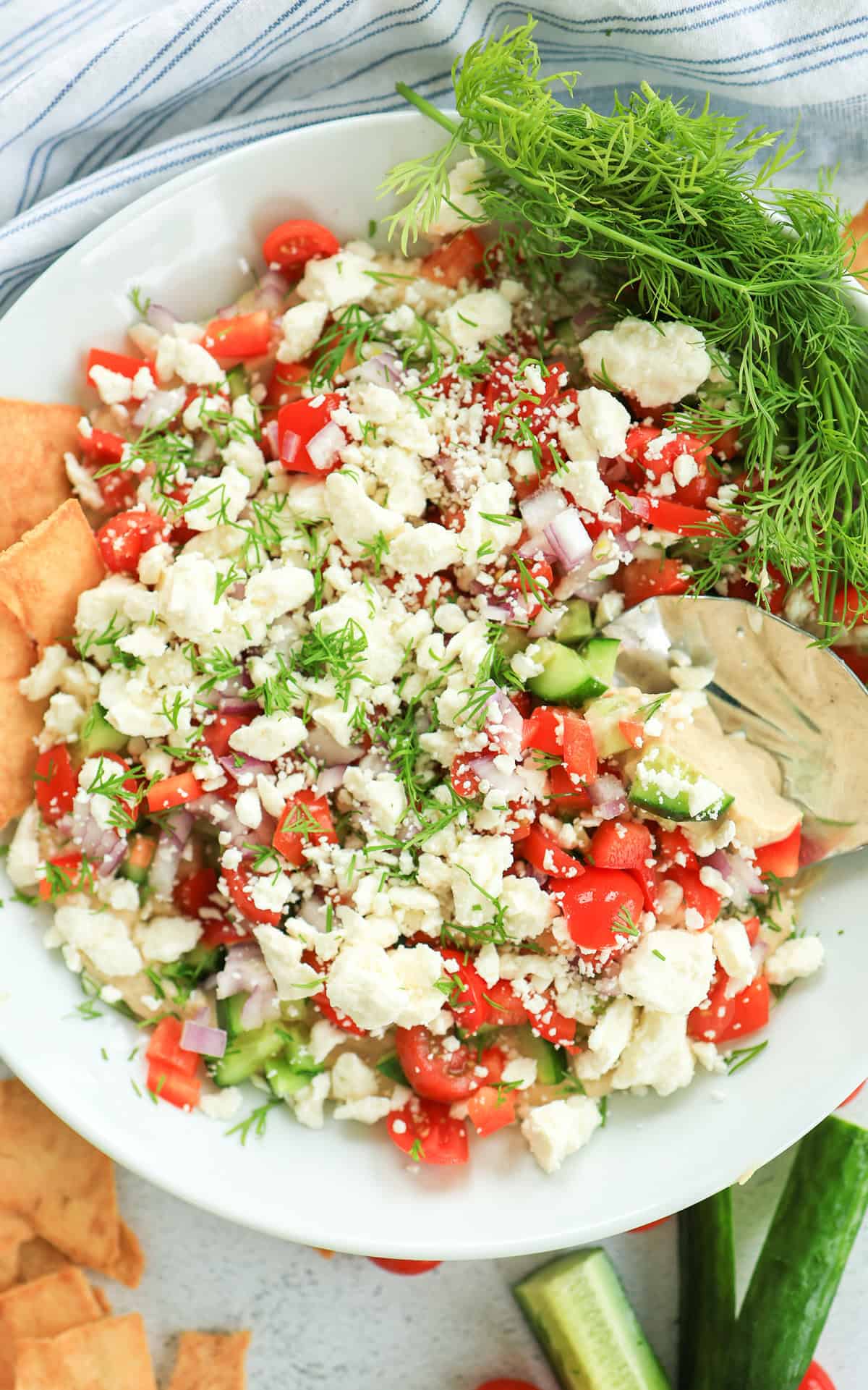 Greek dip topped with with feta cheese, cucumbers and tomatoes.