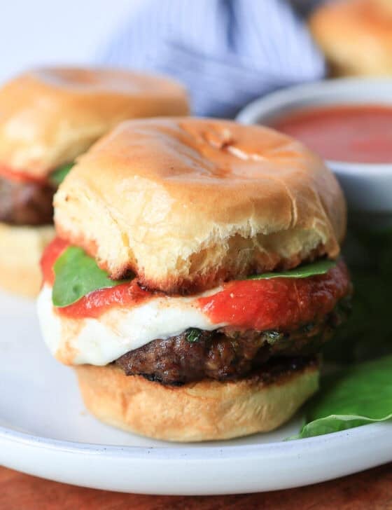 Mini Italian sliders on a plate with extra marinara.