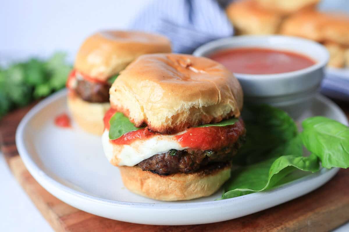 Mini Italian sliders on a plate with extra marinara.