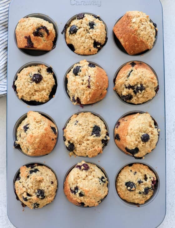 Blueberry oatmeal muffins out of the oven and turned sideways in the muffin tin to cool.
