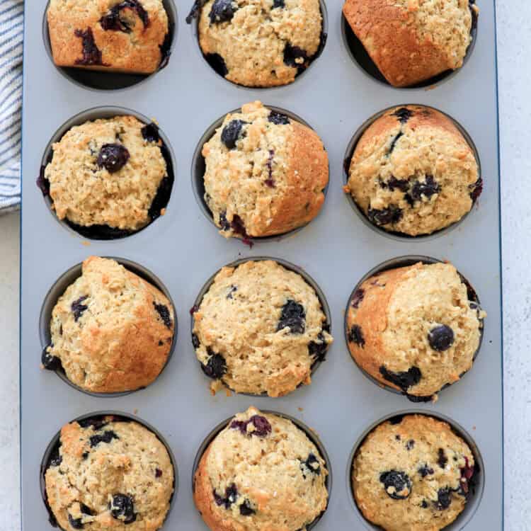 Blueberry oatmeal muffins out of the oven and turned sideways in the muffin tin to cool.