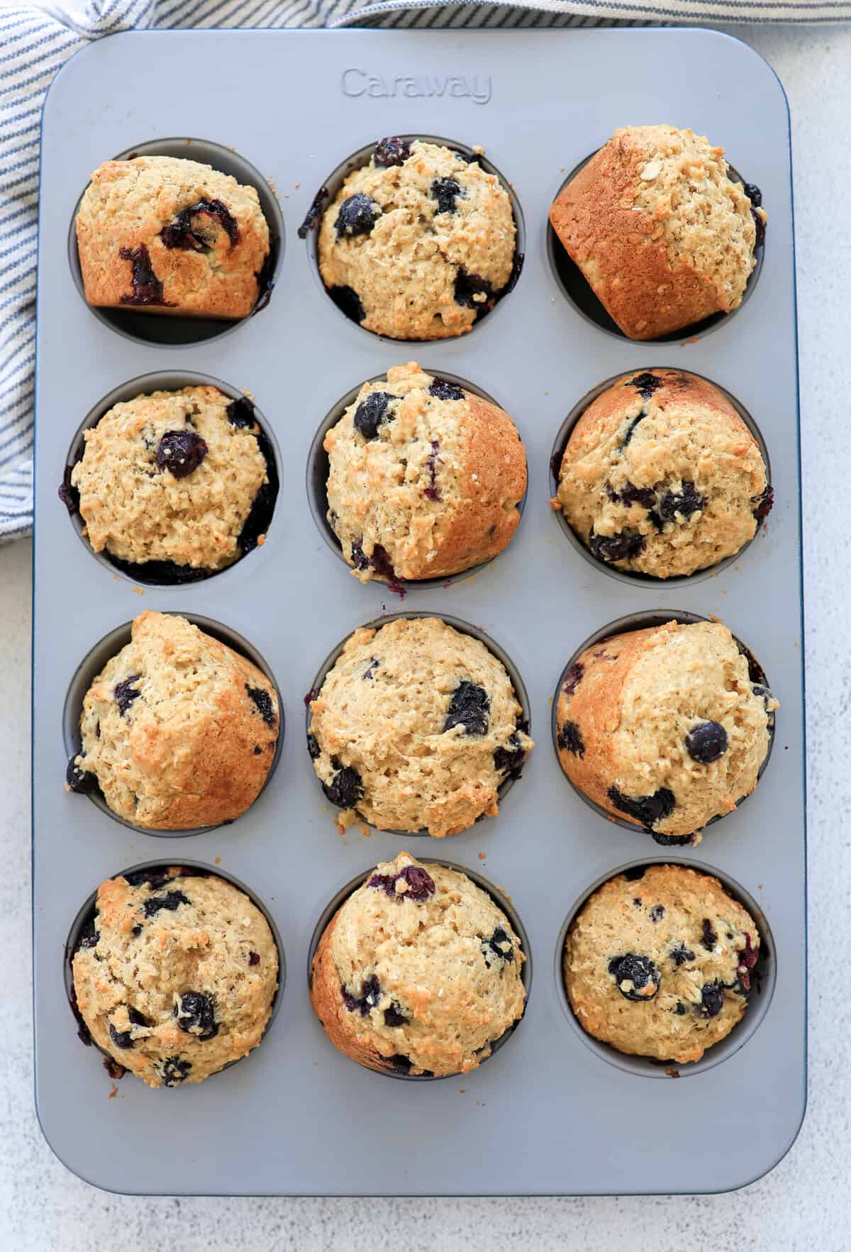 Blueberry oatmeal muffins out of the oven and turned sideways in the muffin tin to cool.
