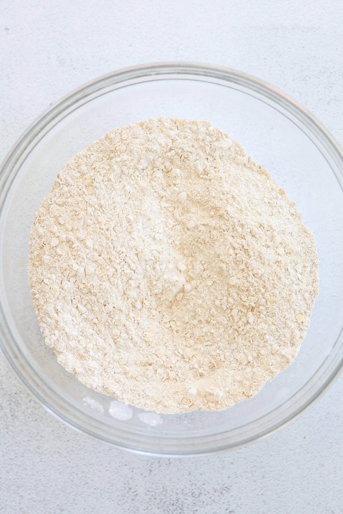 Dry ingredients for muffins mixed together in a glass bowl.