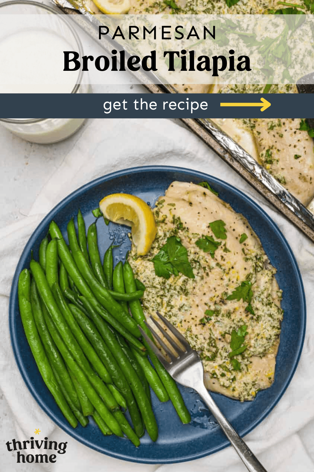 Parmesan broiled tilapia on a plate with green beans.
