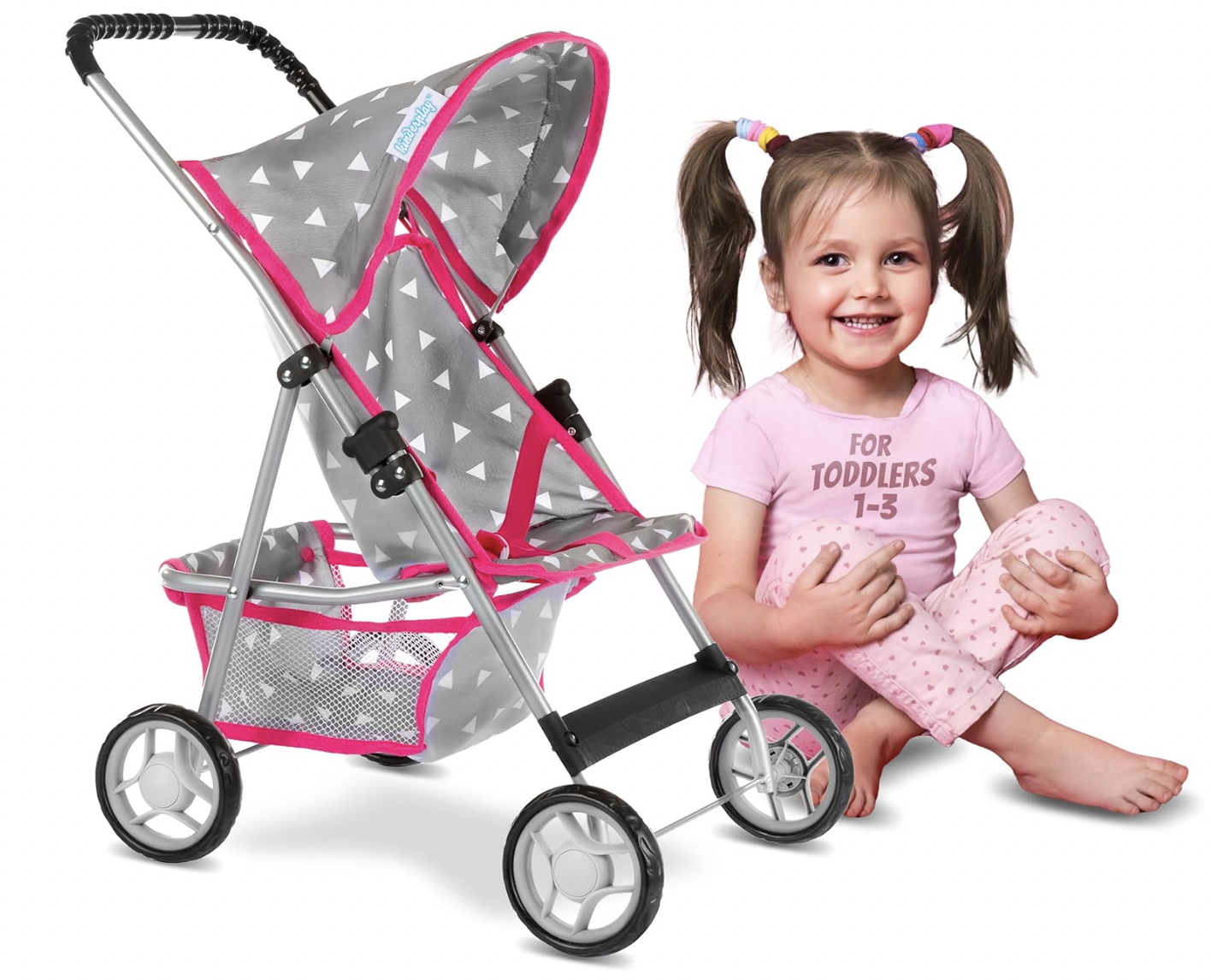 A young girl sitting next to a stroller for dolls.