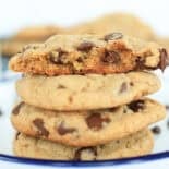 Chocolate chip cookies on a plate with one split in half.