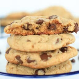 Chocolate chip cookies on a plate with one split in half.