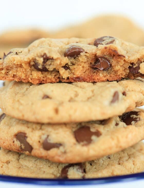Chocolate chip cookies on a plate with one split in half.