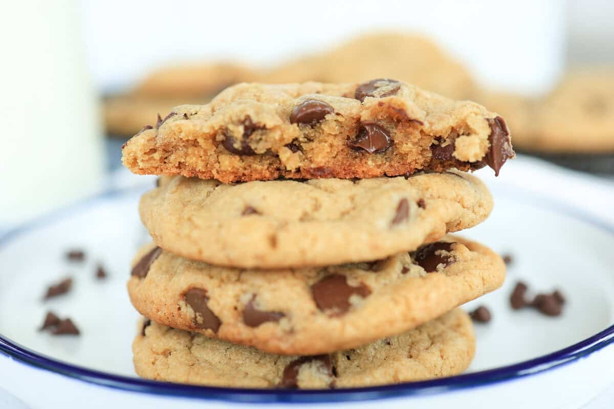 Chocolate chip cookies on a plate with one split in half.