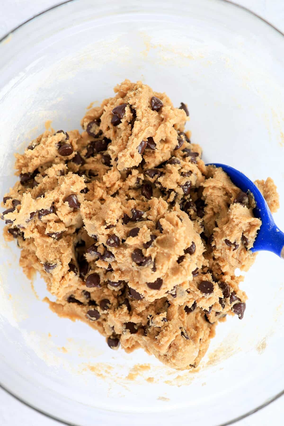 Chocolate chip cookie dough in a glass mixing bowl.
