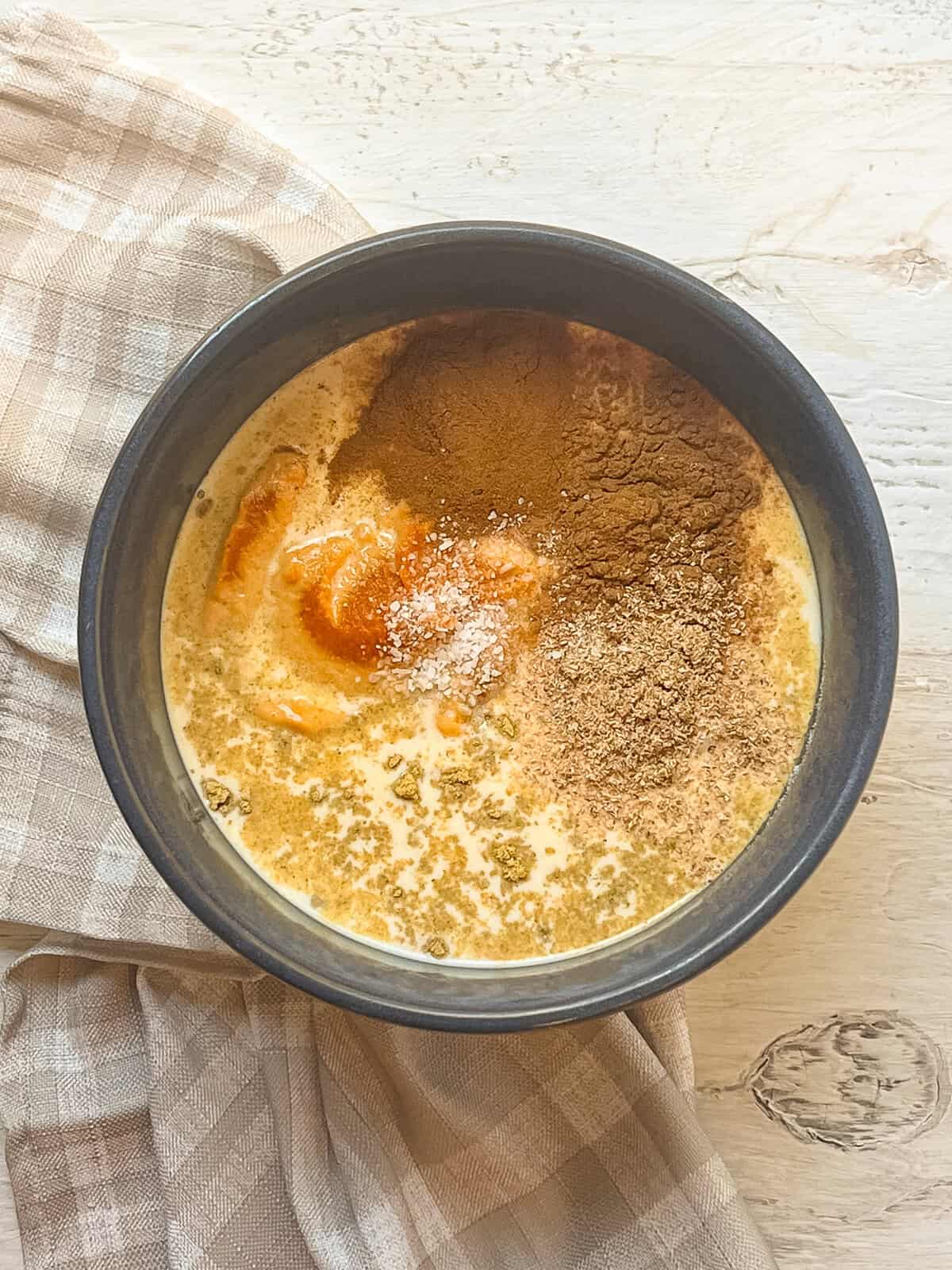 Wet ingredients for pumpkin dump cake in a mixing bowl.