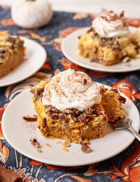Homemade whipped cream on top of a serving of pumpkin dump cake.