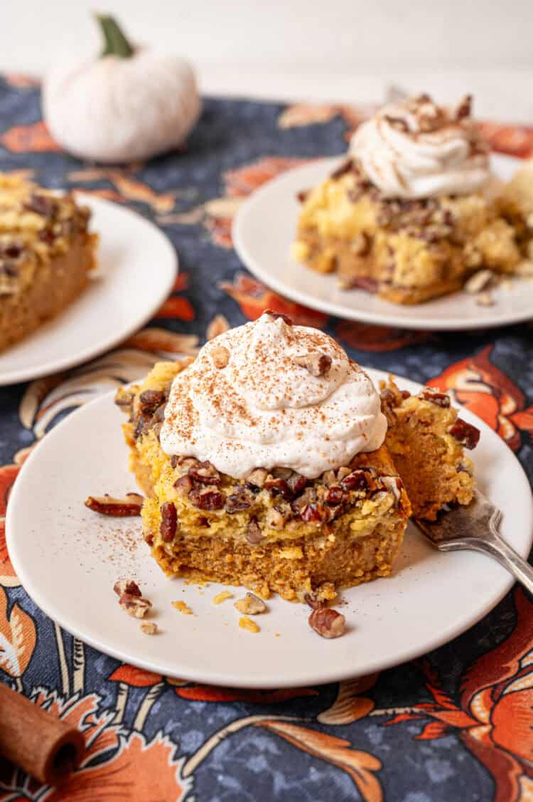 Homemade whipped cream on top of a serving of pumpkin dump cake.